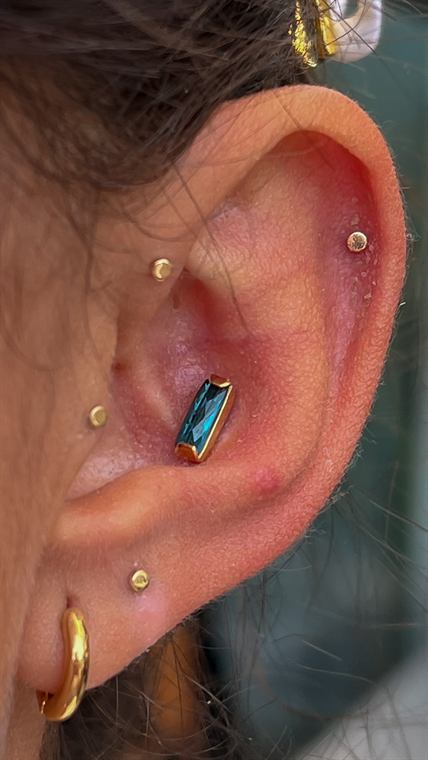 Tragus e conch com joias douradas
