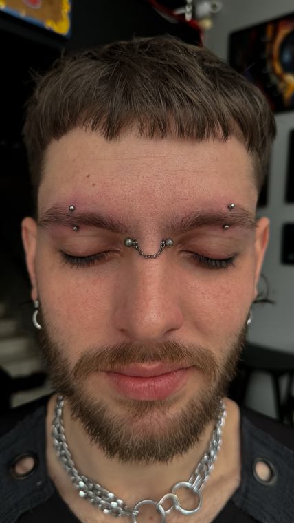 Cliente com piercings na sobrancelha