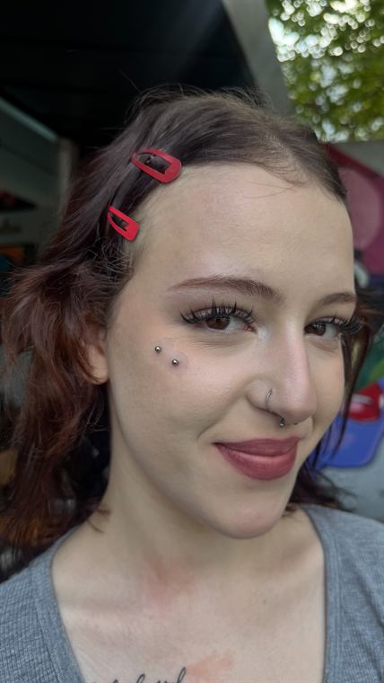 Cliente com piercings faciais