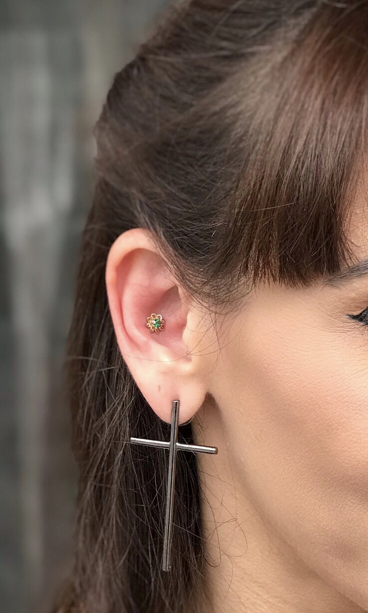 Piercing flor dourada na orelha